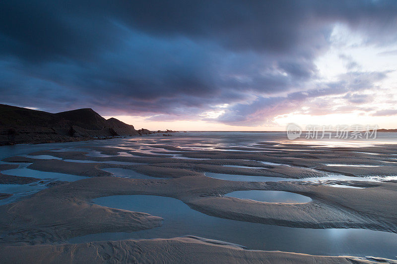 日落反射在潮湿的沙子和海洋在Crackington Haven海滩，康沃尔，英格兰，英国，欧洲